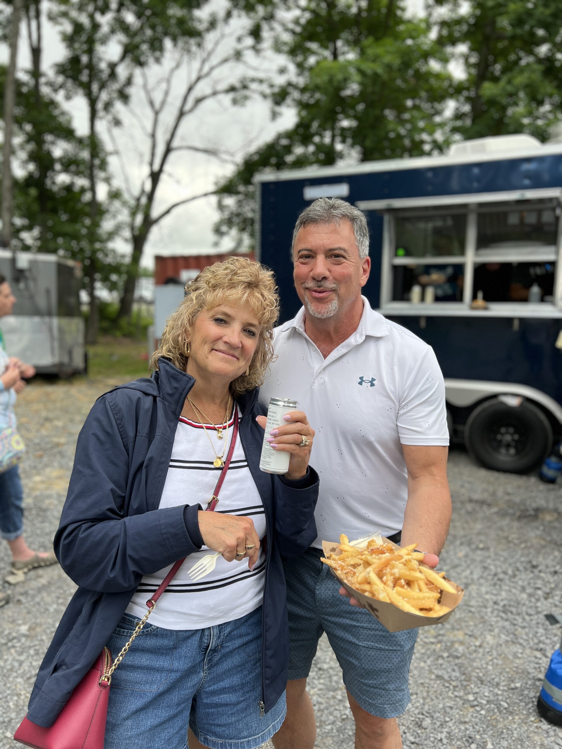 Couple with garlic parm fries at The Park Out food truck at Concerts at Point of the Bluff